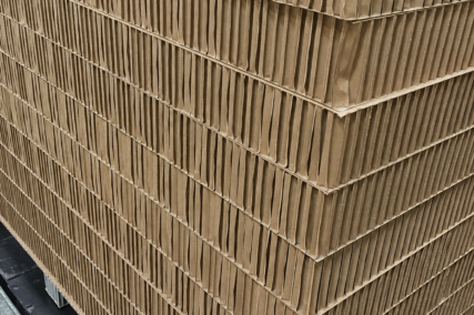Stapel aus fertigen Wabenplatten mit sichtbarer Wabenstruktur aus Karton in einer industriellen Produktionsumgebung