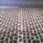 Nahaufnahme einer Papierwabenstruktur mit Maßstab darüber, die die feine hexagonale Zellstruktur eines Honeycomb-Kerns zeigt.