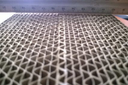 Nahaufnahme einer Papierwabenstruktur mit Maßstab darüber, die die feine hexagonale Zellstruktur eines Honeycomb-Kerns zeigt.