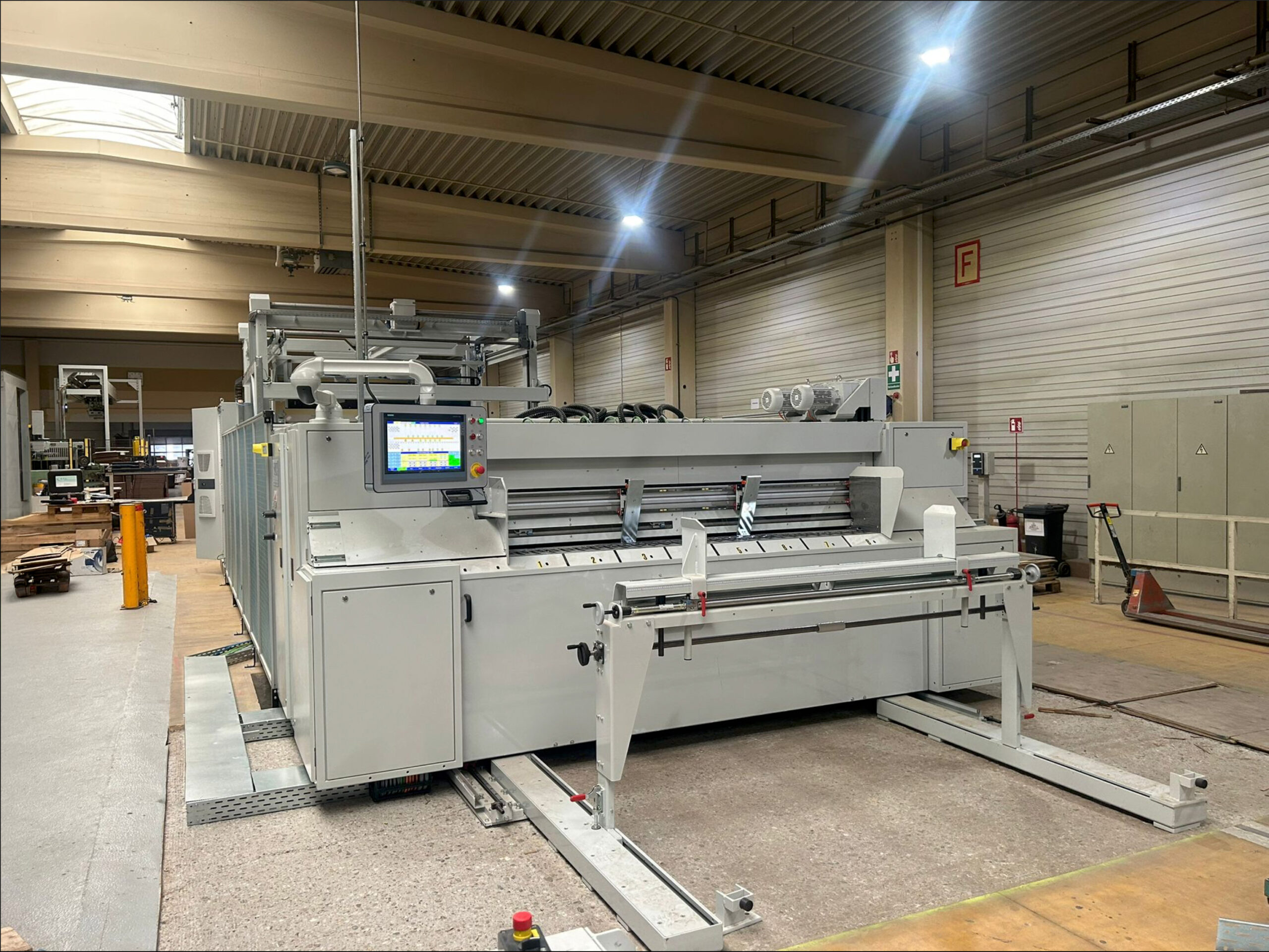 Bedienseite der Schneidmaschine mit Touchscreen-Steuerung und manuellen Einstellelementen.